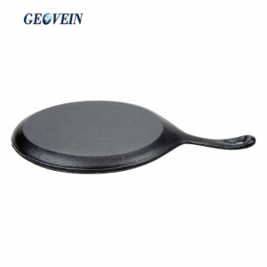 cast iron sizzling steak plate on wooden base