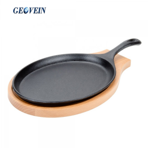 cast iron sizzling steak plate on wooden base